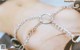 A close up of a person wearing a silver chain bracelet.