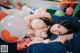 A woman laying on a bed with balloons in the background.