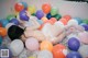 A woman laying on the floor surrounded by balloons.