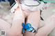 A woman in a maid outfit with a blue butterfly on her thigh.