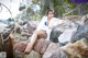 A woman sitting on a rock on the beach.