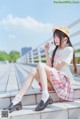 A woman in a school uniform sitting on a bridge.