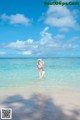 A woman in a bikini standing in the ocean.