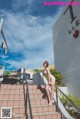 A woman is standing on the steps of a building.