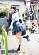 A young woman in a school uniform is posing for a picture.