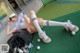 A woman laying on the ground next to a golf bag.