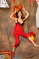 A woman in a red jumpsuit posing for a picture.