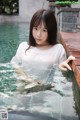 A woman in a white shirt is standing in a pool.