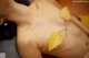 A woman laying on a bed with a yellow leaf on her back.