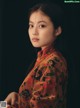 A woman in a floral dress poses for a picture.