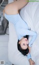 A woman laying on top of a white bed.