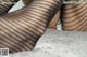 A close up of a woman's legs in fishnet stockings.