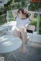 A woman sitting on top of a white table.