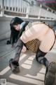 A woman in a school uniform is bending over on the ground.