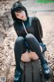 A woman sitting on top of a wooden bench.