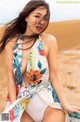 A woman in a bathing suit sitting on a beach.