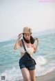 A woman standing on a beach next to the ocean.