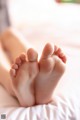 A close up of a person's feet on a bed.