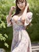 A woman in a floral dress posing for a picture.