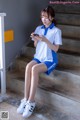 A woman sitting on the steps of a building looking at her phone.