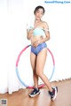 A woman in a blue bikini with a hula hoop.