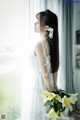 A woman in a white dress holding a bouquet of flowers.