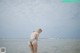 A woman in a bikini standing in the water.