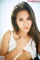 A woman in a white tank top posing for a picture.