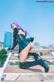 A woman with purple hair is sitting on a set of stairs.