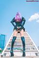 A woman with pink hair standing on a set of stairs.