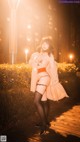 A woman in lingerie posing on a boardwalk at night.