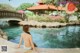 A woman in a blue bikini sitting on the edge of a pool.