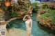 A woman in a white bikini standing in a pool.