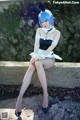 A woman in a bunny costume sitting on a stone wall.