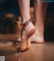 A woman's bare feet in the sand on a beach.