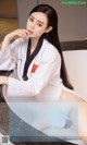 A woman in a white kimono sitting on a counter.