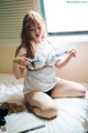 A woman sitting on a bed holding a pair of scissors.