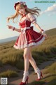 A woman in a red and white dress is walking in a field.