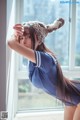 A woman in a bunny hat leaning against a window.