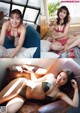 A woman in a bikini sitting on a couch with a dog.