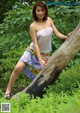 A woman sitting on a log in the woods.